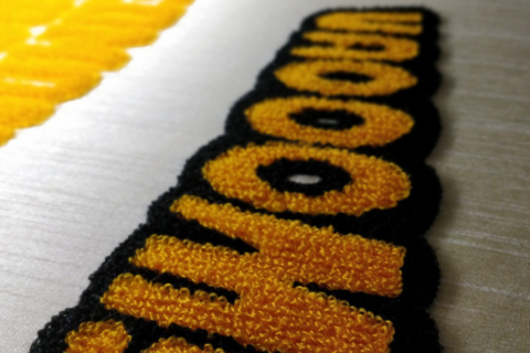 Close-up of 3D textured chenille embroidery showing raised, plush stitching used in Octanbro’s apparel branding
